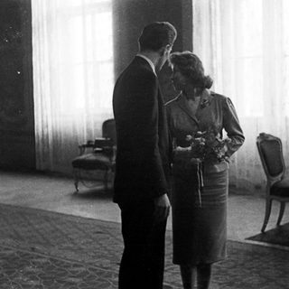 Couple stands near a table in a room.