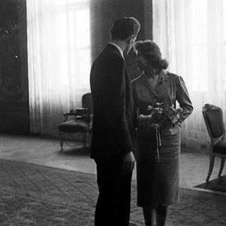 Couple stands near a table in a room.