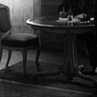 Couple stands near a table in a room.