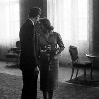Couple stands near a table in a room.