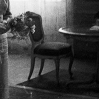 Couple stands in room, likely after a wedding.