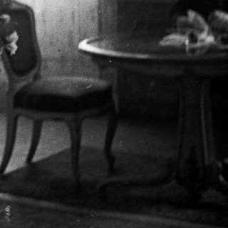 Couple stands in room, likely after a wedding.