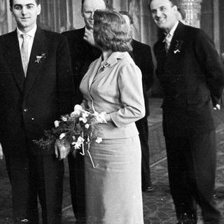 Black and white photo of a wedding party indoors.
