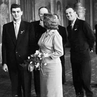 Black and white photo of a wedding party indoors.