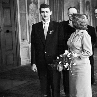 Black and white photo of a wedding party indoors.