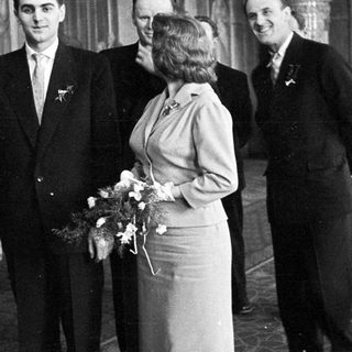 Black and white photo of a wedding party indoors.