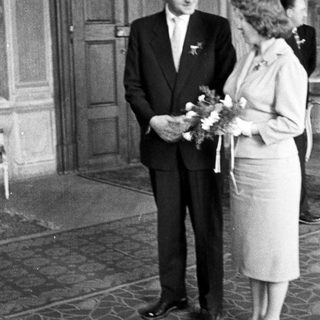 Black and white photo of a couple standing after a wedding.