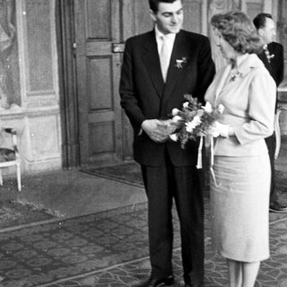 Black and white photo of a couple standing after a wedding.