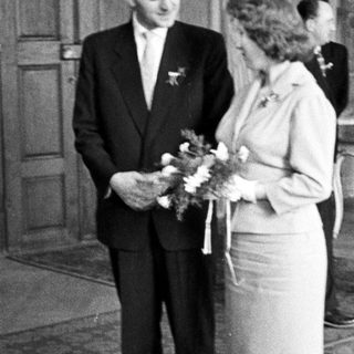 Black and white photo of a couple standing after a wedding.