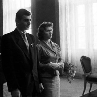 Couple standing with a man in a formal setting.
