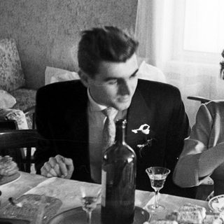 Couple seated at a table with food and drinks.