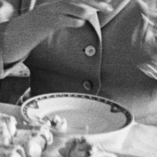 Couple seated at a table with food and drinks.