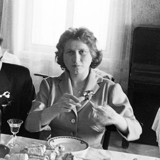 Couple seated at a table with food and drinks.