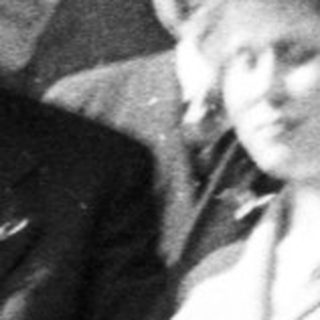 Couple exits building, surrounded by men, in vintage attire.