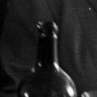 Here's a brief summary of the image: Black and white photo of a couple seated at a table.