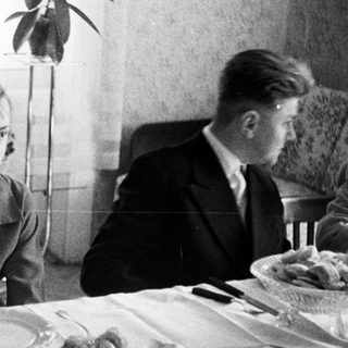 Black and white photo of people seated at a table.