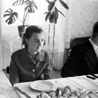 Black and white photo of people seated at a table.