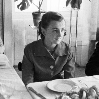 Black and white photo of people seated at a table.