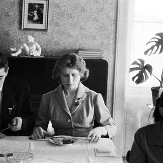 Black and white photo of three people at a table.