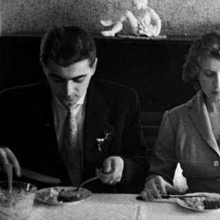 Black and white photo of three people at a table.