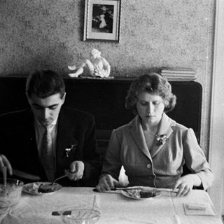 Black and white photo of three people at a table.