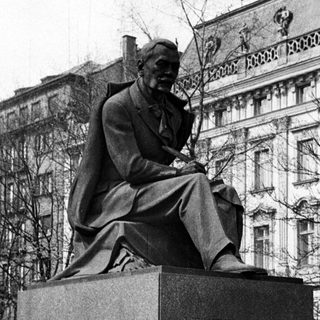 Black and white photo of a statue and building.