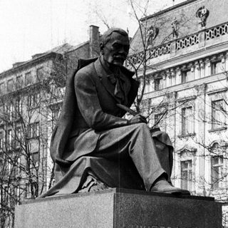 Black and white photo of a statue and building.