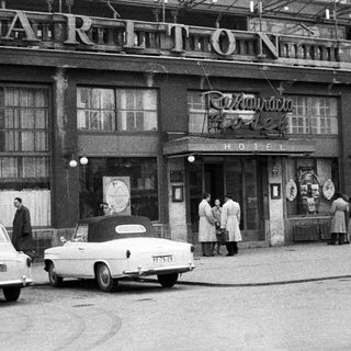 Black and white photo of a hotel and cars.