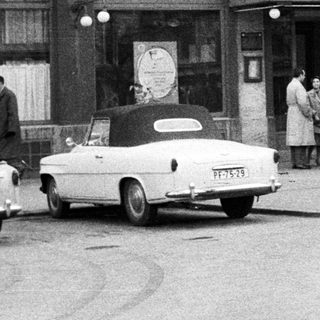 Black and white photo of a hotel and cars.