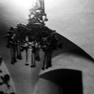 A black and white photo of a hanging chandelier.