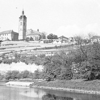 Black and white photo of a town with a church spire.