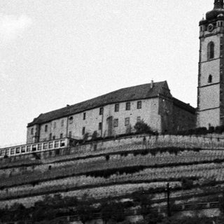 Monastery complex situated on a hillside with a prominent tower.