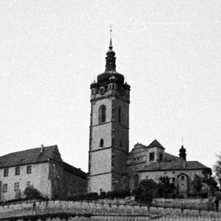 Monastery complex situated on a hillside with a prominent tower.