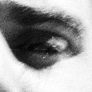 Here's a brief summary of the image: Black and white portrait of a man with slicked-back hair.