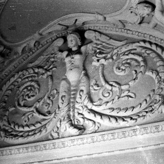 Detailed ornamental carving featuring figures and foliage.