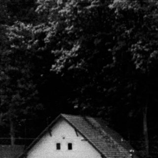 Black and white photo shows a large castle on a hill.