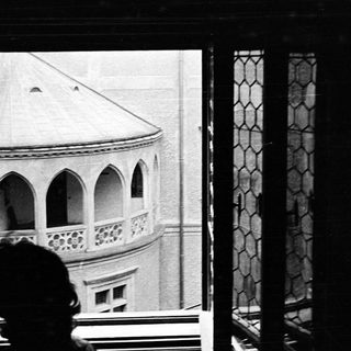 Person looking out a window at a building.