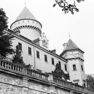 Black and white photo of a castle with stone balconies.