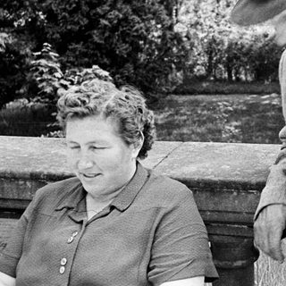 Man and woman outdoors, possibly interacting, in black and white.