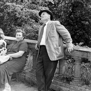 Black and white photo of three people on a bench.