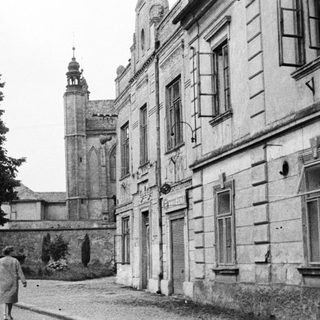 Monochrome street scene with statue, building, and a person.