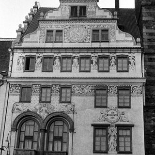 Here's a brief summary of the image: Elaborate facade of a historic building with statues.