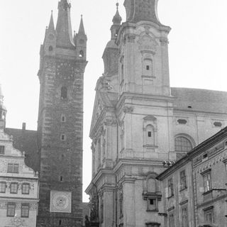 Black and white photo of a tower and church facade.