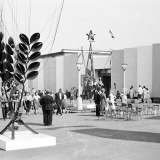 Soviet exhibit at an international exposition, featuring sculpture and crowds.