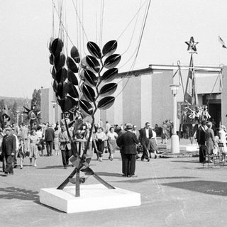 Soviet exhibit at an international exposition, featuring sculpture and crowds.