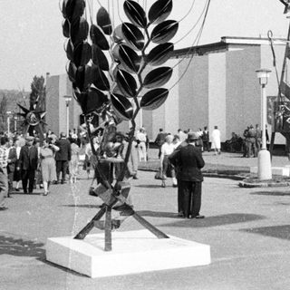 Soviet pavilion with sculpture and crowd during an event.