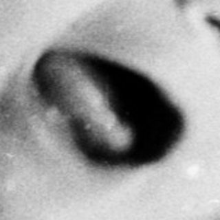 Black and white image of a baby in a crib.