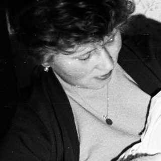 Woman holding a baby, possibly in a home setting.