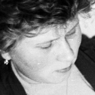 Woman holding a sleeping baby in a vintage photograph.