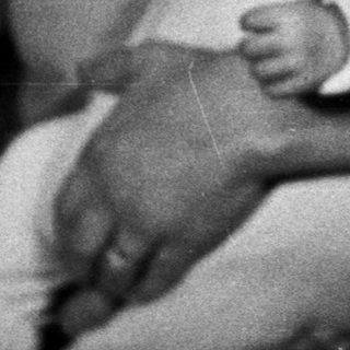 Woman holds baby, possibly during the holiday season.